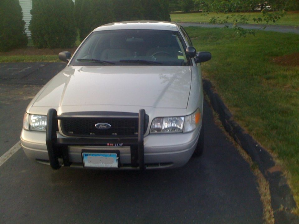 Front view of a silver 2009 Ford Crown Victoria with a black push bar and a license plate