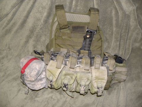 1995 Ford Bronco - A tactical vest with numerous pouches and an American flag patch is displayed against a textured background.