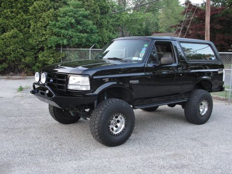 1995 Ford Bronco - This black 1995 Ford Bronco features a custom front bumper and large off-road tires, giving it a appearance.