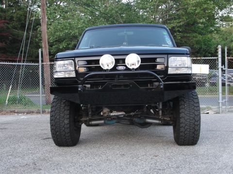 1995 Ford Bronco - Front view of a black Ford Bronco with an aftermarket bumper and auxiliary lights.