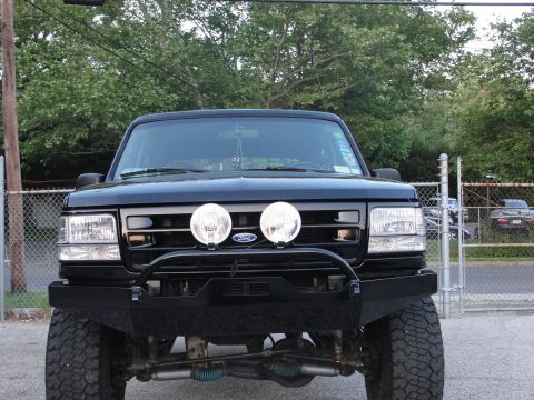 1995 Ford Bronco - Front view of a black 1995 Ford Bronco, modified with an aftermarket bumper and auxiliary lights.