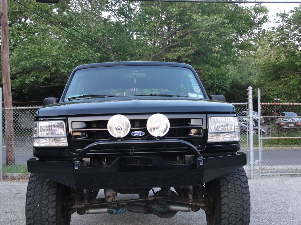 Front view of black 1995 Ford Bronco with custom bumper and dual spotlights