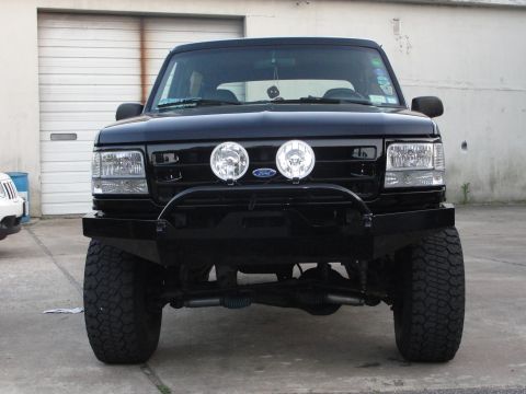 1995 Ford Bronco - Front view of a black 1995 Ford Bronco equipped with an aftermarket bumper and driving lights.