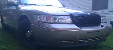 2000 Mercury Grand Marquis - This 2000 Mercury Grand Marquis features a distinctive black grille and a silver exterior, captured from a 3/4 front perspective.
