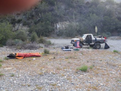1991 Ford Bronco - 1991 Ford Bronco parked in a dry, rocky area with camping gear laid out.