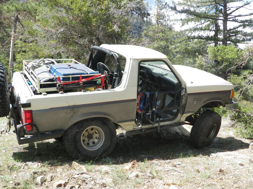 Off-road modified 1991 Ford Bronco with gear in the back and no doors