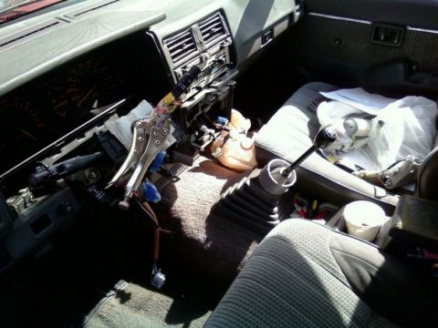 2000 Mercury Grand Marquis - The interior of a car shows a disassembled dashboard with wires exposed and vice grips attached.