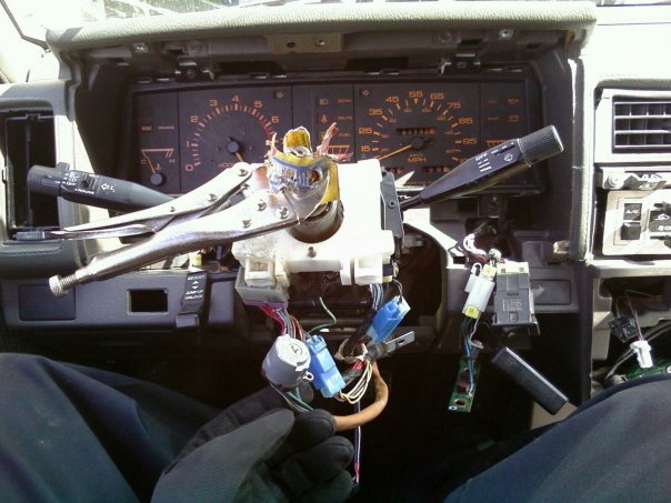 Disassembled dashboard with vice grips on steering column