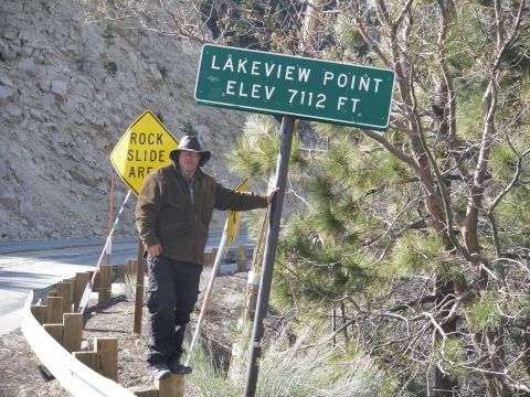 1991 Ford Bronco - Man poses by the Lakeview Point sign, which indicates an elevation of 7112 feet. A rock slide warning sign is also present.