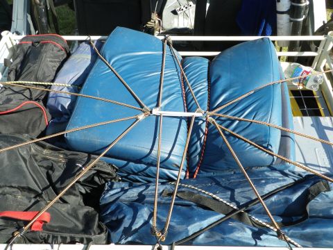 1991 Ford Bronco - Luggage and cushions are secured in the back of a vehicle with a web of ropes.