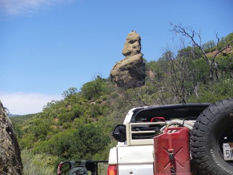1991 Ford Bronco - A white SUV is parked on a rocky trail with a distinctive rock formation in the background.