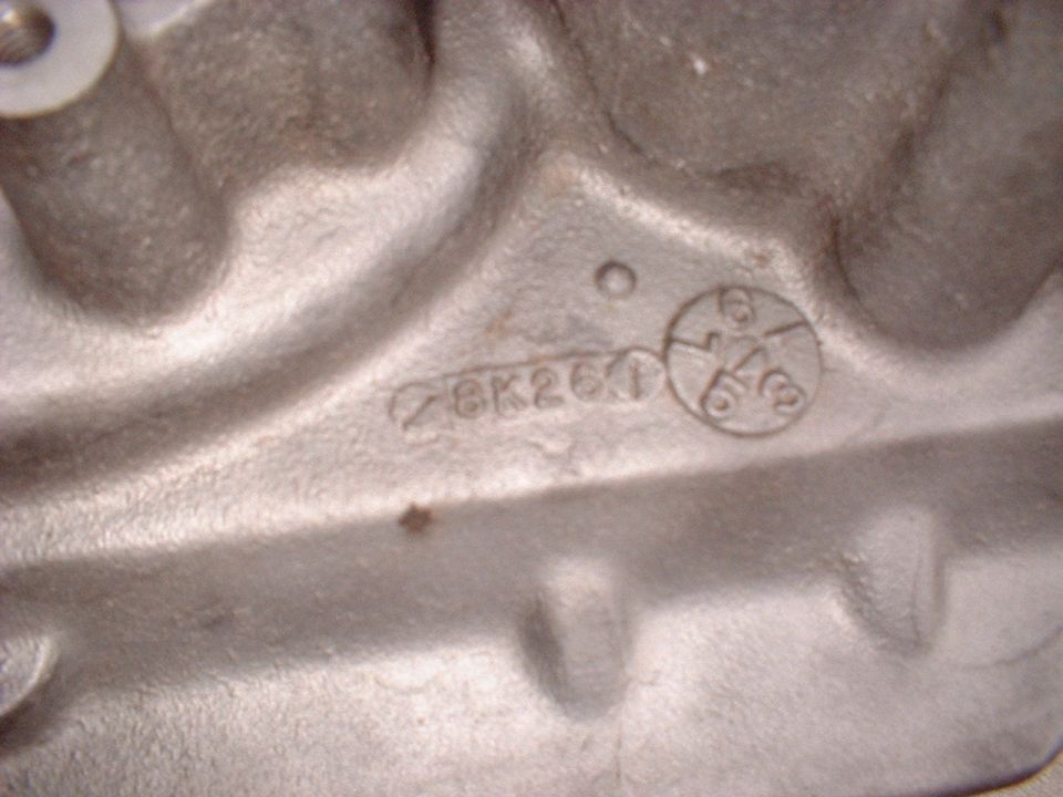 Close-up of engine block casting showing numbers 28K260 and a circular stamp with 6 and 3