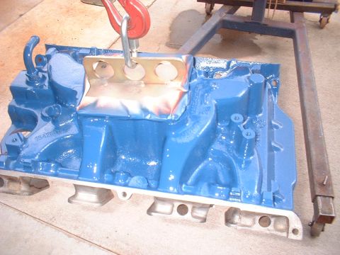 1969 Ford Torino - Engine block painted blue and suspended by a lifting hook, with SuperMotors.net logo visible.