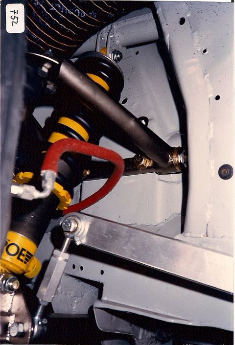 1973 Ford Mustang - Detail of a car's front suspension system, showing shock absorber and linkage components.