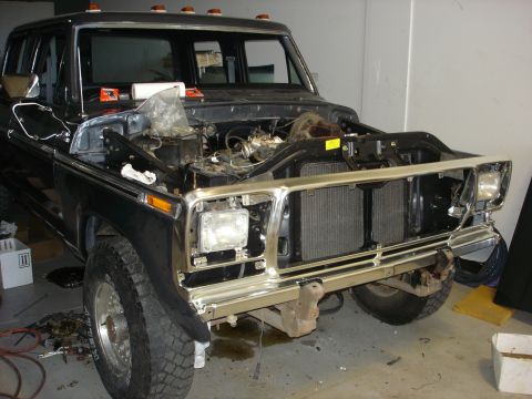 1979 Ford F-250 - Front view of a 1979 Ford F-250 truck undergoing repairs, with the hood open and grille removed.