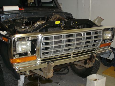 1979 Ford F-250 - The front grille and headlights of a 1979 Ford F-250 truck are visible, with the hood open to reveal the engine compartment.