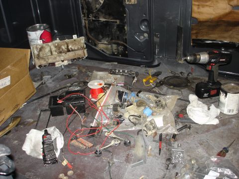 1979 Ford F-250 - Vehicle interior disassembled with electrical parts, tools, and supplies laid out for work.