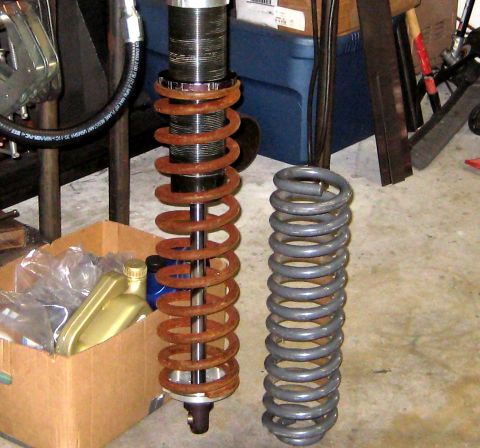 1996 Ford Bronco - Two coil springs, one rusty and one gray, are shown next to a shock absorber assembly.