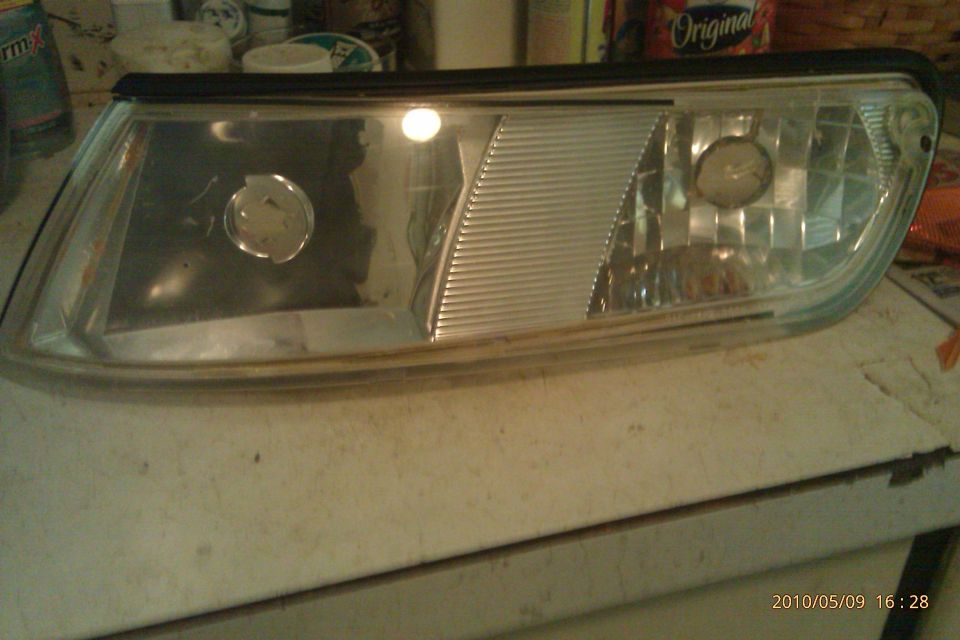 Headlight assembly with clear lens and ribbed section. Sitting on a table