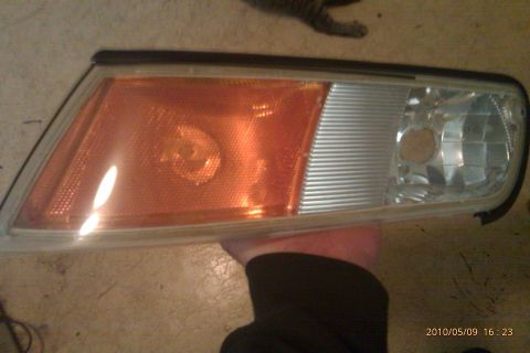 2000 Mercury Grand Marquis - A clear corner light assembly is held, showing its amber and clear sections. The registry label of 2000 Mercury Grand Marquis is likely inc…