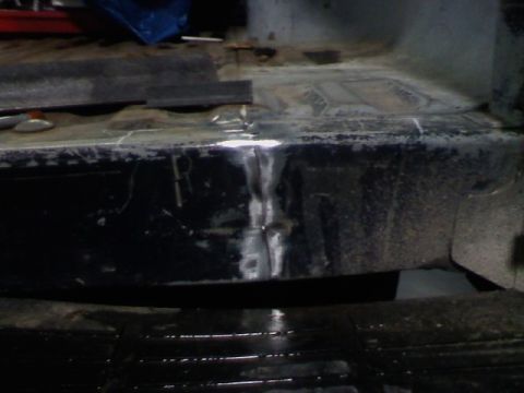 1991 Ford F-150 - Close-up view of a welded frame section, with a leaf spring visible beneath.