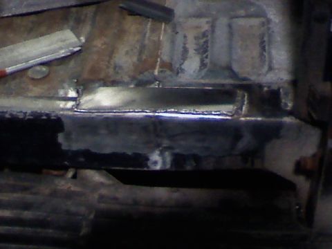 1991 Ford F-150 - This image shows a section of metal that has been welded and repaired, likely on a vehicle's undercarriage or frame.