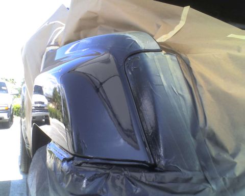1993 Ford C-350 (Centurion Conversions) - A vehicle's rear bumper and fender are covered in masking paper and tape, likely for painting.