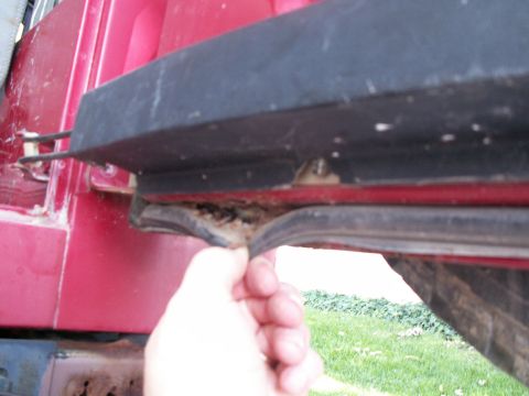 1988 Jeep YJ - Close-up of a red vehicle's door seal being inspected.