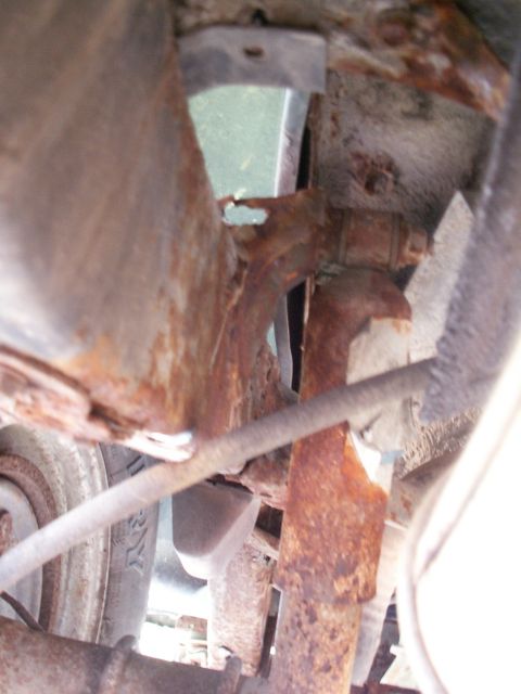 1988 Jeep YJ - The underside of a vehicle shows significant rust and corrosion on its frame and suspension parts.