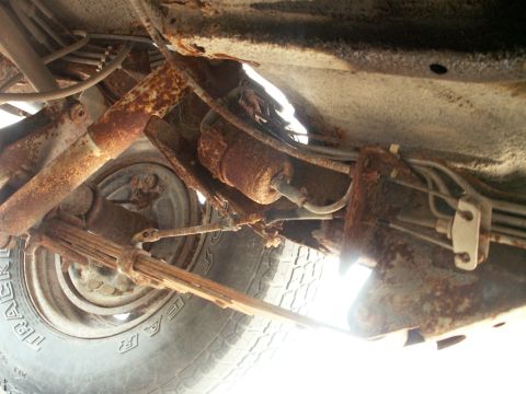 1988 Jeep YJ - The underside of a heavily rusted vehicle, revealing leaf springs and suspension components.