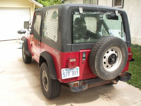 1988 Jeep YJ - 1988 Jeep YJ Wrangler seen from the rear, parked in a driveway.