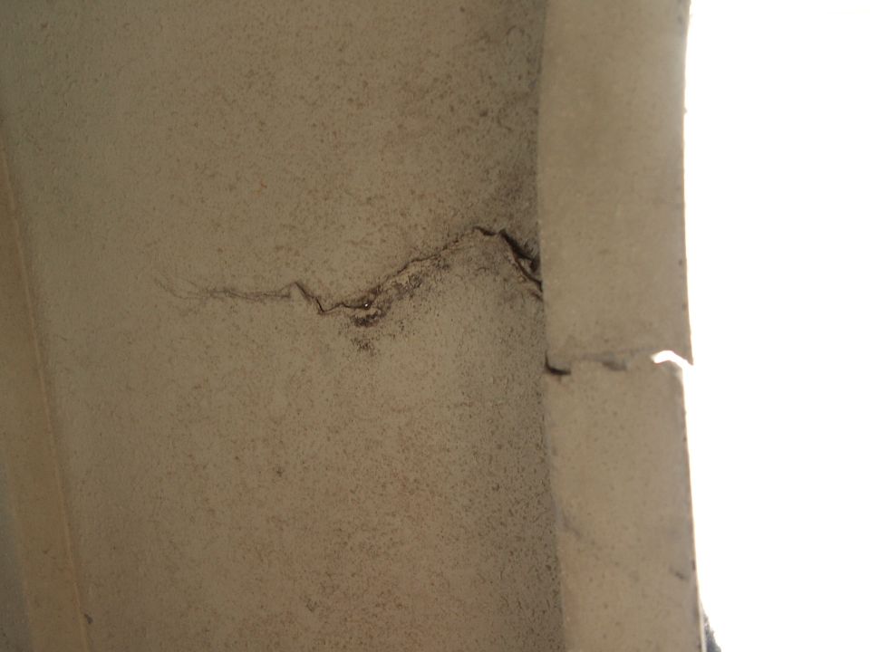 Close-up of a cracked beige panel with dark staining along the fracture