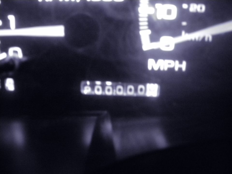 Odometer showing 000000 miles with speedometer in background