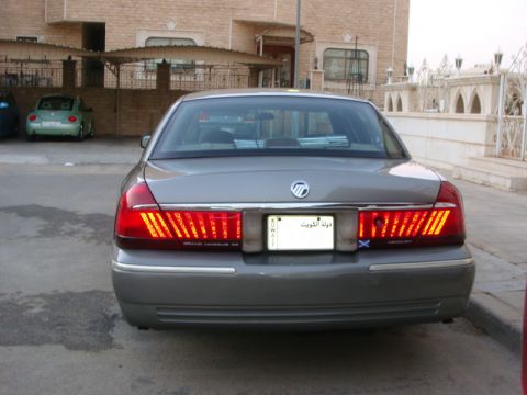 2001 Mercury Grand Marquis - Rear view of a 2001 Mercury Grand Marquis, with a green VW Beetle visible in the background.