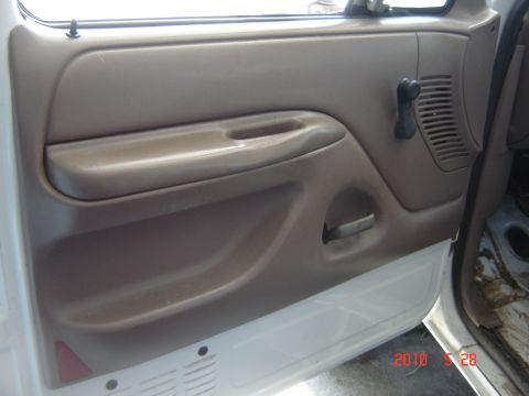 1993 Ford Bronco - Close-up of a vehicle's interior door panel, showing the window crank and storage pocket.