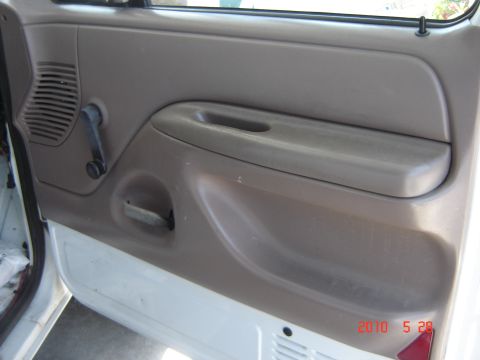 1993 Ford Bronco - Close-up of a vehicle's interior door panel, showing the window crank and speaker grille.