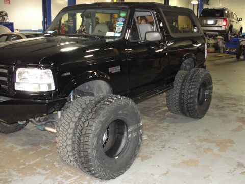 1995 Ford Bronco - Black 1995 Ford Bronco modified with dual rear tires, parked indoors.