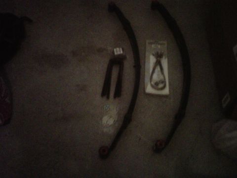 1981 Toyota Hilux - A pair of leaf springs and a U-bolt kit are laid out on a carpeted surface.