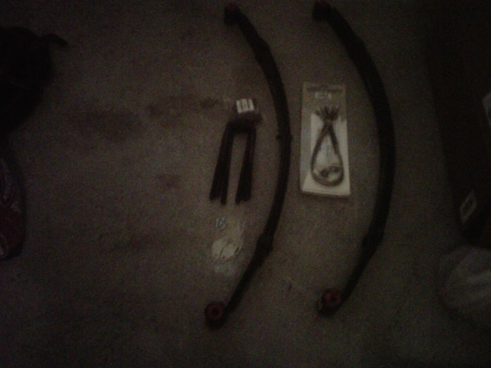 Two leaf springs and a U-bolt kit on the floor