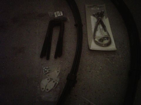 1981 Toyota Hilux - Various automotive parts are laid out on a dark surface, including metal brackets and cables.
