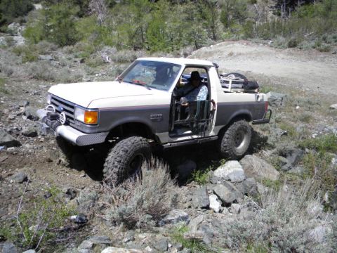 1991 Ford Bronco - This modified Ford Bronco navigates a rocky, off-road path with its doors removed.