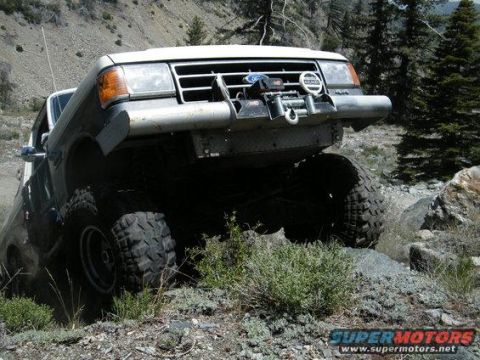 1991 Ford Bronco - This modified truck navigates a rocky, off-road path in a mountainous, wooded area.