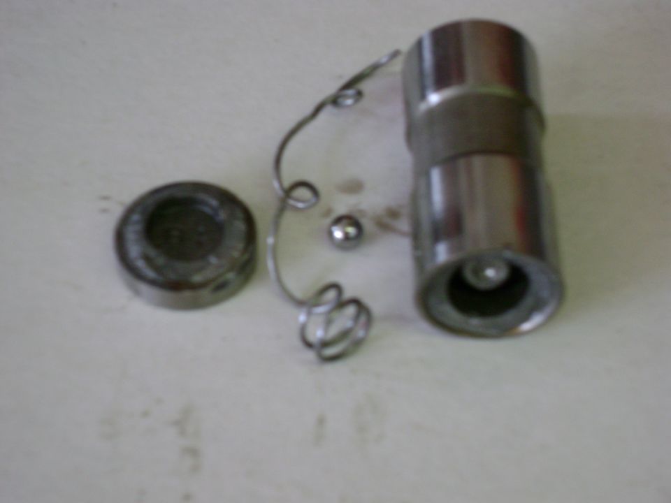Disassembled hydraulic lifter with body, plunger cap, spring and check ball on a bench