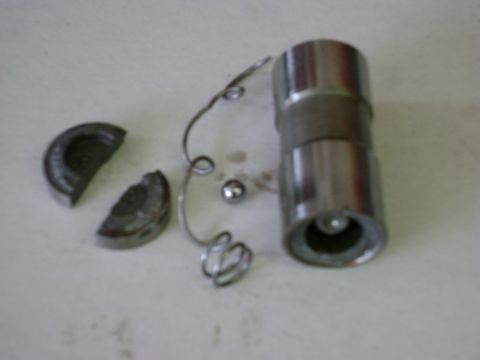 1972 Ford Ranchero - Disassembled engine lifter components are laid out on a white surface, showing a roller, spring, and two broken metal pieces.