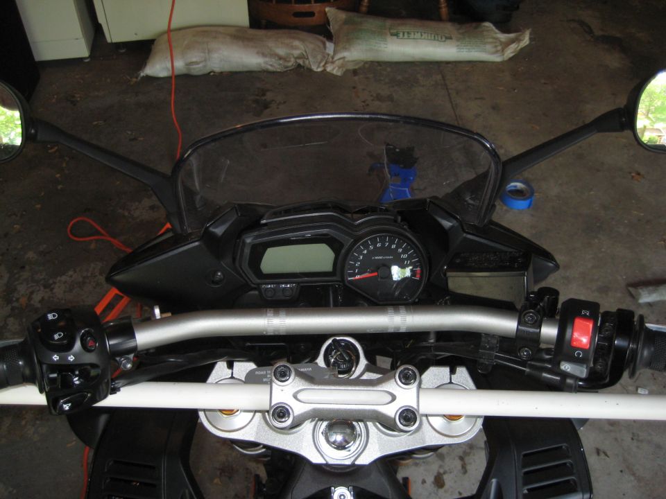 Motorcycle handlebars, digital display, and analog tachometer. Supermotors.net logo visible