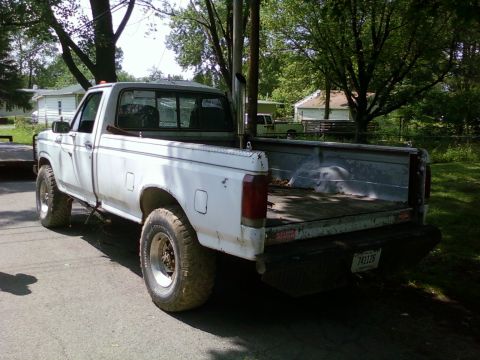 1989 Ford Bronco - This 1987 Ford F-150 pickup truck features a prominent exhaust stack and is parked outdoors.