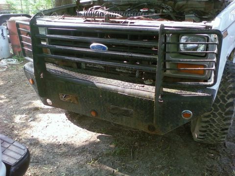 1989 Ford Bronco - A white Ford Bronco with a heavy-duty brush guard and bumper is shown from the front.
