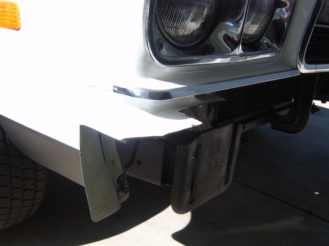 White 1973 Ford Ranchero front bumper with damage and torn air dam