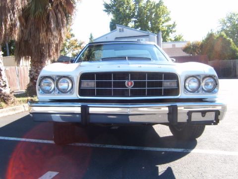 1973 Ford Ranchero - The front end of a white pickup truck is shown, a large grille and dual headlights.