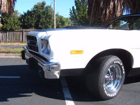 1973 Ford Ranchero - A white pickup truck is viewed from the front corner, showing its grille and bumper.